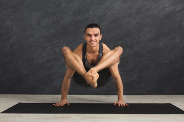 Young flexible man standing on hands