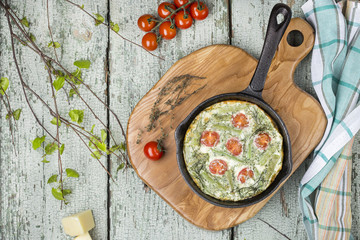 classic omelet with cherry tomatoes, cheese and herbs