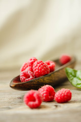 Fresh sweet raspberry and green basil in a wooden plate. Calm gamma. Close-up..Selective focus....