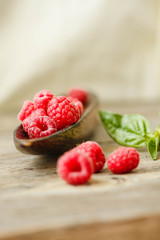 Fresh sweet raspberry and green basil in a wooden plate. Calm gamma. Close-up..Selective focus.Organic.Copy space.