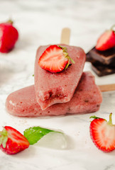 Strawberry ice cream with a banana and chocolate on a stick. Summer fresh dessert. Mint. Detox diet and summer food concept.Selective focus.
