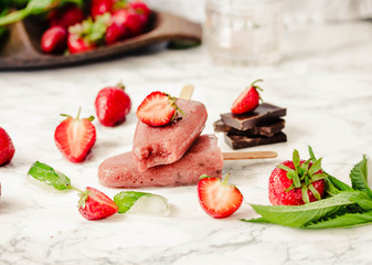 Strawberry ice cream with a banana and chocolate on a stick. Summer fresh dessert. Mint. Detox diet and summer food concept.Selective focus.