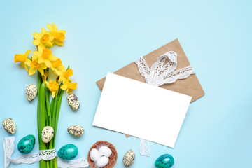 easter greeting card with easter eggs and spring flowers mock up over blue background. mock up