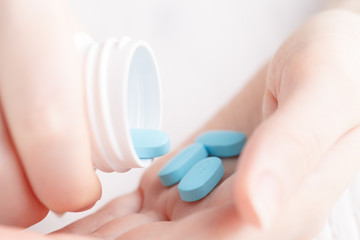 young woman pours out medicine into her hand