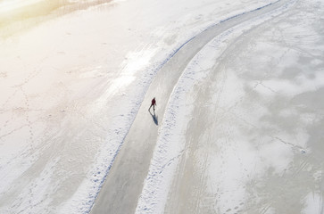 Man ice-skating of frozen lake. Aerial view