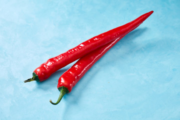 Burning fresh red hot pepper on a blue background, top view, close-up