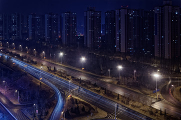 Fototapeta na wymiar Looking on the skyscraper in a row and a motorway by night, Shenyang, China