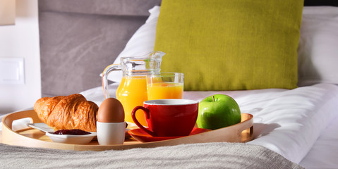 Breakfast on tray in bed in hotel room