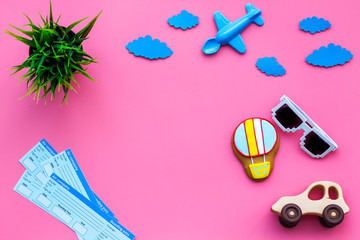 Sample of airplane ticket. Family trip with kid. Airplan, car and air balloon toys. Pink background flat lay space for text