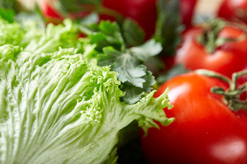 Close-up still life of assorted fresh vegetables and herbs on wooden rustic background, top view, selective focus.