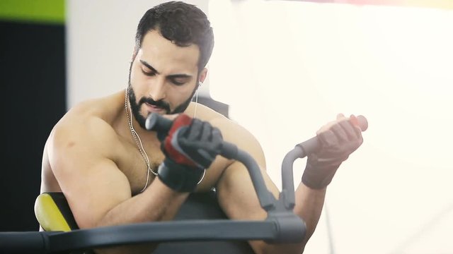 Handsome bearded man does arms workout in the gym