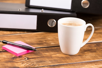 business desk with coffee cup, paper, pen and folder