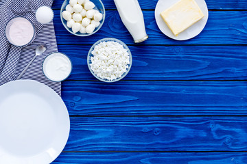 Fresh dairy products. Milk, cottage, cheese, yougurt on blue wooden table top view mock up