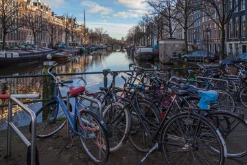 Papier Peint photo Lavable Canal water canals in Amsterdam with a bridge in the middle and traditional architecture with bicycles