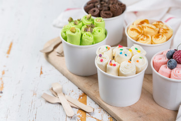Selection of different rolled ice creams in cone cups