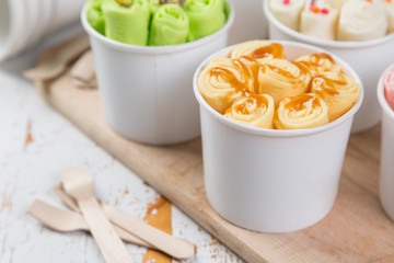 Selection of different rolled ice creams in cone cups