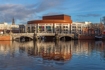 Dutch National Opera and Ballet building reflecting in canal water on a sunny day