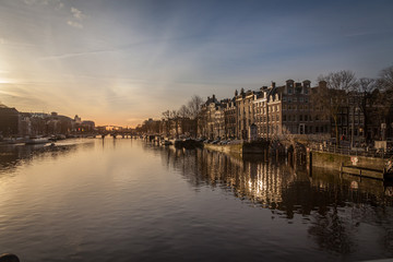 sunset in Amsterdam over river Amstel traditional architecture