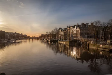 Papier Peint photo Canal sunset in Amsterdam over river Amstel traditional architecture