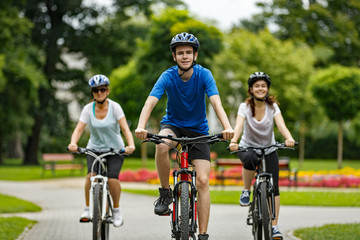 Fototapeta na wymiar Healthy lifestyle - people riding bicycles in city park