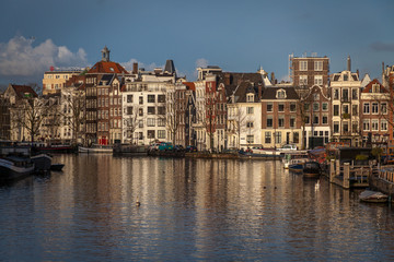 Fototapeta na wymiar water canals in Amsterdam with traditional architecture reflecting in the water on a sunny day