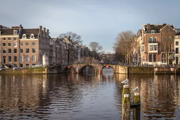 Tableaux ronds sur plexiglas Anti-reflet Canal water canals in Amsterdam with a bridge in the middle and traditional architecture