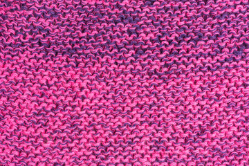 knitted fabric background with garter stitch pattern in shades of pink