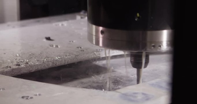 Close-up of a water jet metal cutting machine in slow motion