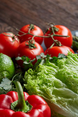 Close-up still life of assorted fresh vegetables and herbs on wooden rustic background, top view, selective focus.
