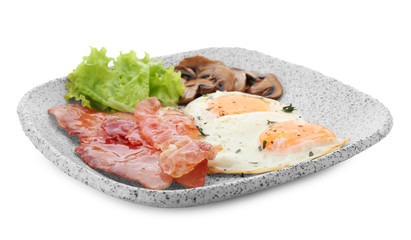 Plate with fried eggs, bacon, mushrooms and lettuce on white background