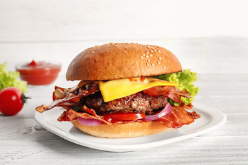 Tasty burger with bacon on plate