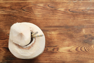 Fresh coconut drink in nut on wooden background
