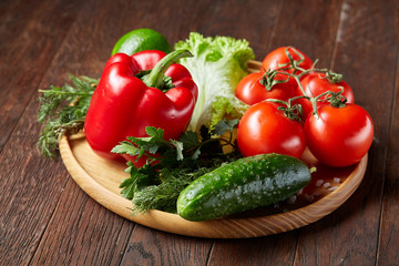 Close-up still life of assorted fresh vegetables and herbs on vintage wooden background, top view, selective focus.