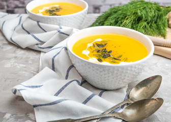 Delicious creamy homemade pumpkin soup with cream and pumpkin seed garnish.