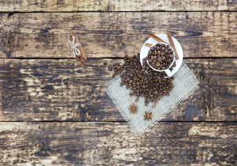 Grain coffee in a cup, which stands on a sackcloth from burlap. Cinnamon on a platter and tied with a rope. Anise stars complement the aroma of coffee. View from above.