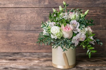 Wedding bouquet in a box on a wooden background