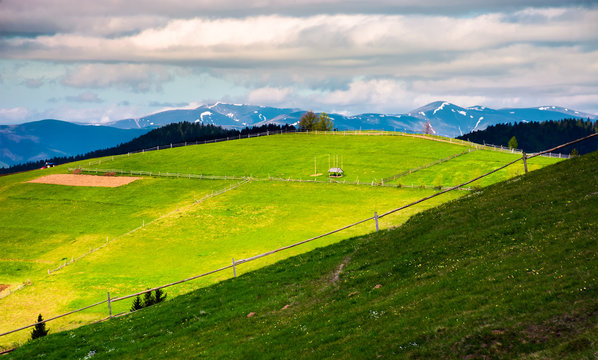 fence on a grassy slope of Carpathian rural area. beautiful landscape on a cloudy springtime day