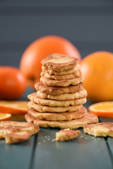 Healthy snack. Pile of homemade cookies and oranges on dark blue background