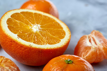 Variety of fresh citrus fruits for making juice or smoothie over light textured background, top view, selective focus.