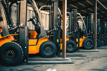Background of a lot of forklifts, reliable heavy loader, truck - obrazy, fototapety, plakaty