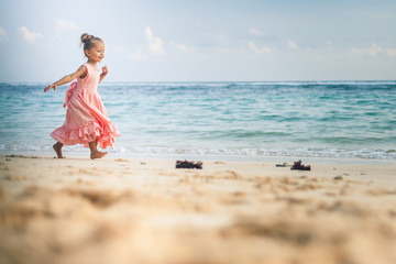 Beautiful little girl at the beach. Sunblock cream for children.