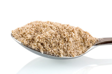 Medicinal Isabgol, ispaghula or psyllium husks on a stainless steel spoon isolated on white background with shadow reflection. Psyllium seed coat on a scoop on white backdrop.