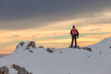 Alpinist on a snow covered crest at sunset, Col Visentin, Belluno, Italy