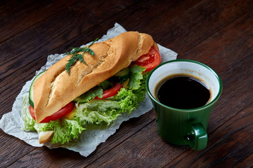 Lunch sandwich with cheese and vegetables served with citrus and coffee, selective focus, close-up, top view