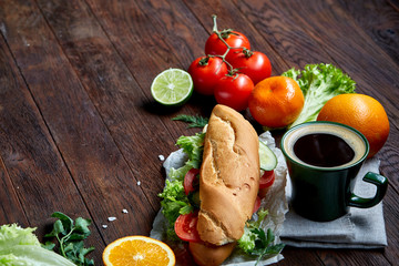 Lunch sandwich with cheese and vegetables served with citrus and coffee, selective focus, close-up, top view