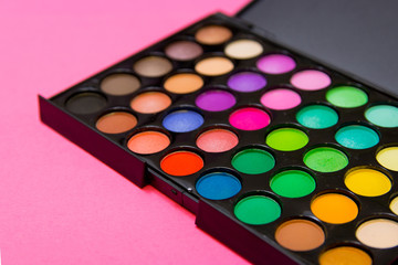 Eyeshadow on pink background. Decorative cosmetics for professional makeup. Concealers. Eyeshadow trend colors, glamour makeup