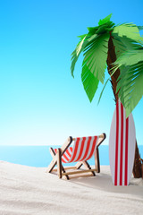 Tropical still life. Dawn on the sandy coast with palm trees. A chaise longue and a surfboard on the beach