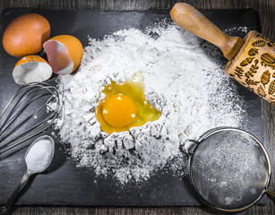 beginning of kneading the dough - a hill of flour, a broken egg, appliances