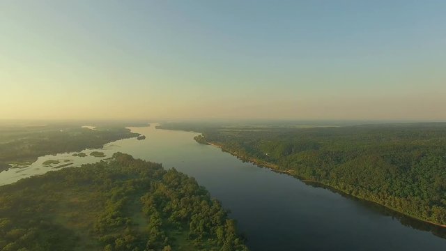aerial view of river at sunrise 4K, forest and river in morning mist, Very high view of the river forest at sunrise, Aerial view of mystical river at sunrise with fog, sun above the river aerial