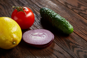 Still life of fresh organic vegetables on wooden plate over wooden background, selective focus, close-up